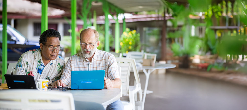 two men working on laptops