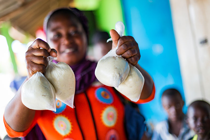 girl giving bundles of food