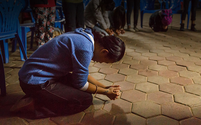 woman on knees, praying