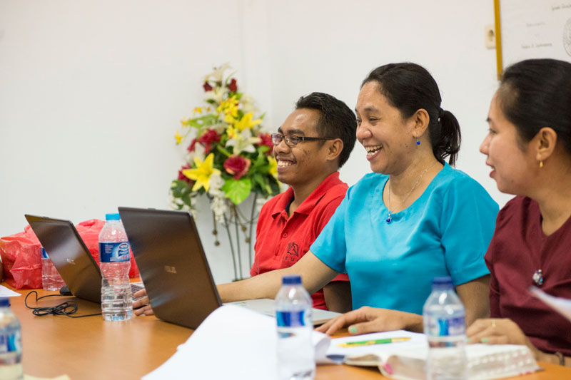 Three people from the translation team working at their computers.